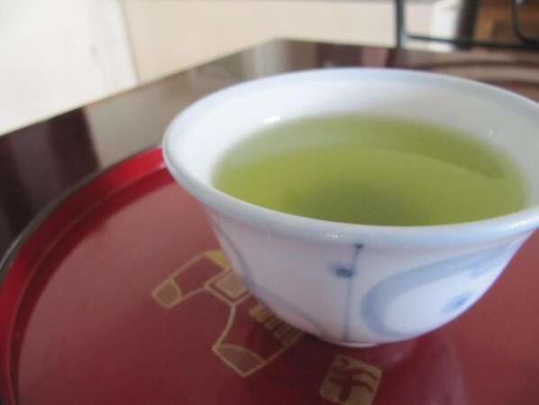 A white cup with a blue pattern on a red tray with a logo.