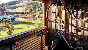 A rustic wooden room with a view of a green landscape, a bicycle, and a metal-framed window. - Ashdowns of Dover B&B (Dover)