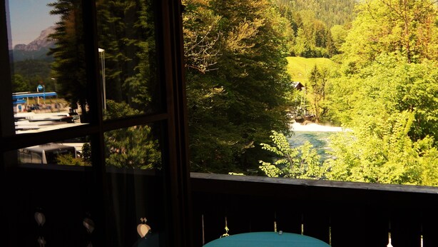 A room with a view of a forested valley and a river. - Hotel Königsseer Hof (Schoenau am Koenigssee)
