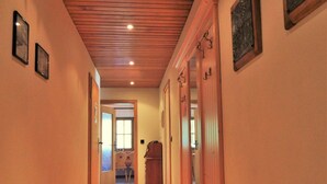 A hallway with wooden flooring, wooden doors, and framed pictures on the walls. - Hotel Königsseer Hof (Schoenau am Koenigssee)