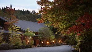 A traditional Japanese building with a tiled roof, surrounded by a gravel path and various trees. - Yufuin Ryoan Wazanhou (Yufu)
