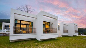A modern, white, two-story building with large windows and balconies, set against a twilight sky. - Sea & Pine Pension (Namhae)