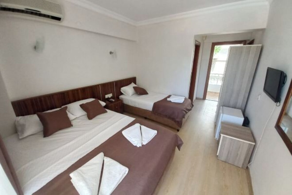 Una habitación de hotel con dos camas, un televisor y un escritorio pequeño.