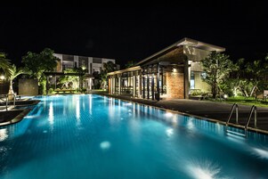 Una piscina al aire libre, sillones reclinables de piscina