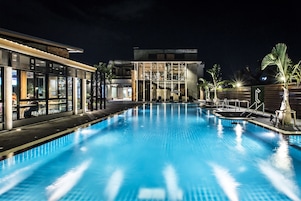 Una piscina al aire libre, sillones reclinables de piscina