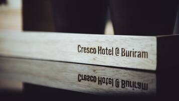 A wooden sign with the text "Cresco Hotel @ Buriram" indicating the hotel's name and location.