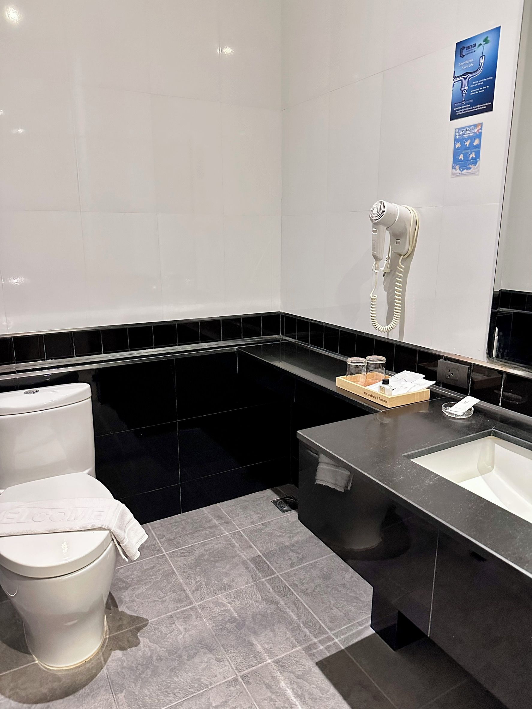 Ein modernes Badezimmer mit Toilette, Fön und Waschbecken.