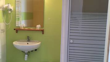 A bathroom with a sink, mirror, and a small stool.