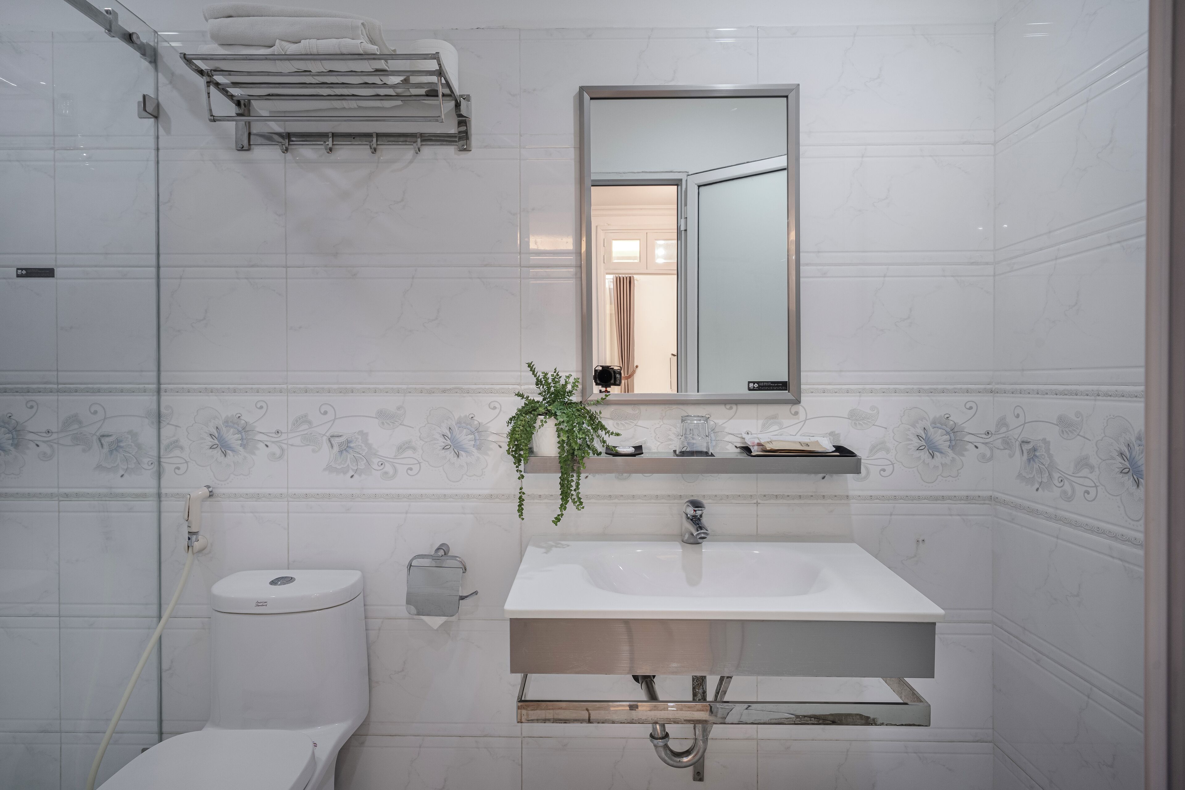 A bathroom with a white sink, a toilet, a shower, and a mirror.