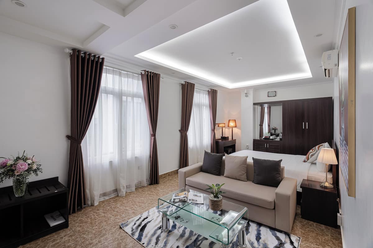 A modern living room with a sofa, glass coffee table, and a TV.
