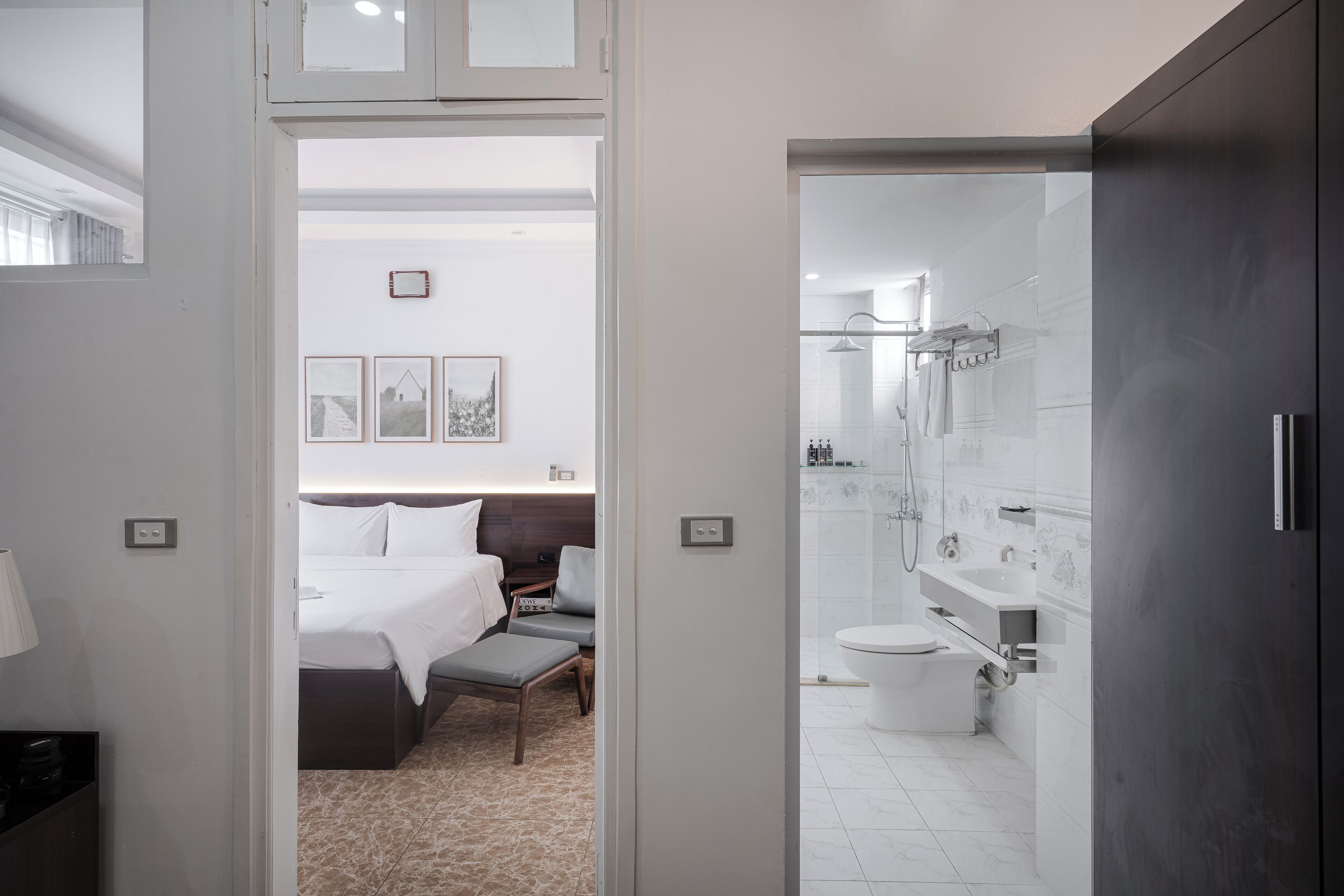 A modern hotel room with a bed, bedside table, and a view of the bathroom.