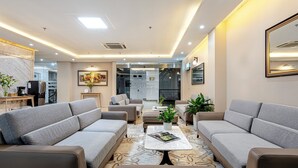 Uma sala de estar moderna com sofás cinzas, uma mesa de centro e uma lareira.