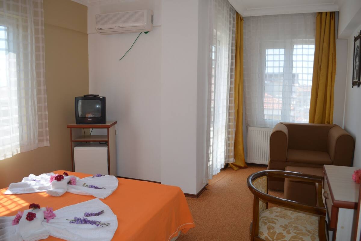 A hotel room with a bed, a television, a chair, and a table.