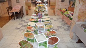 A buffet setup with various food items arranged on tables. - Megas Hotel (Ayvalik)
