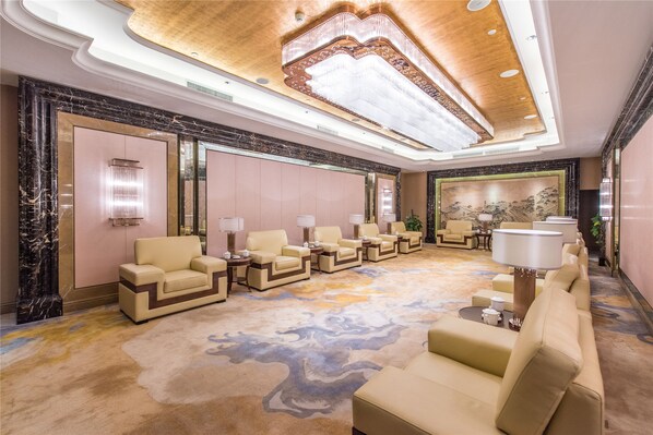 A spacious lobby with a marble floor, multiple seating areas, and a large mural on the wall. - Qianjiang Junting Hotel, Haining (Jiaxing)