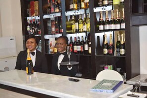 A bar area with a marble countertop, a bottle of champagne, and a wine glass. - Citiheight Hotel (Lagos)