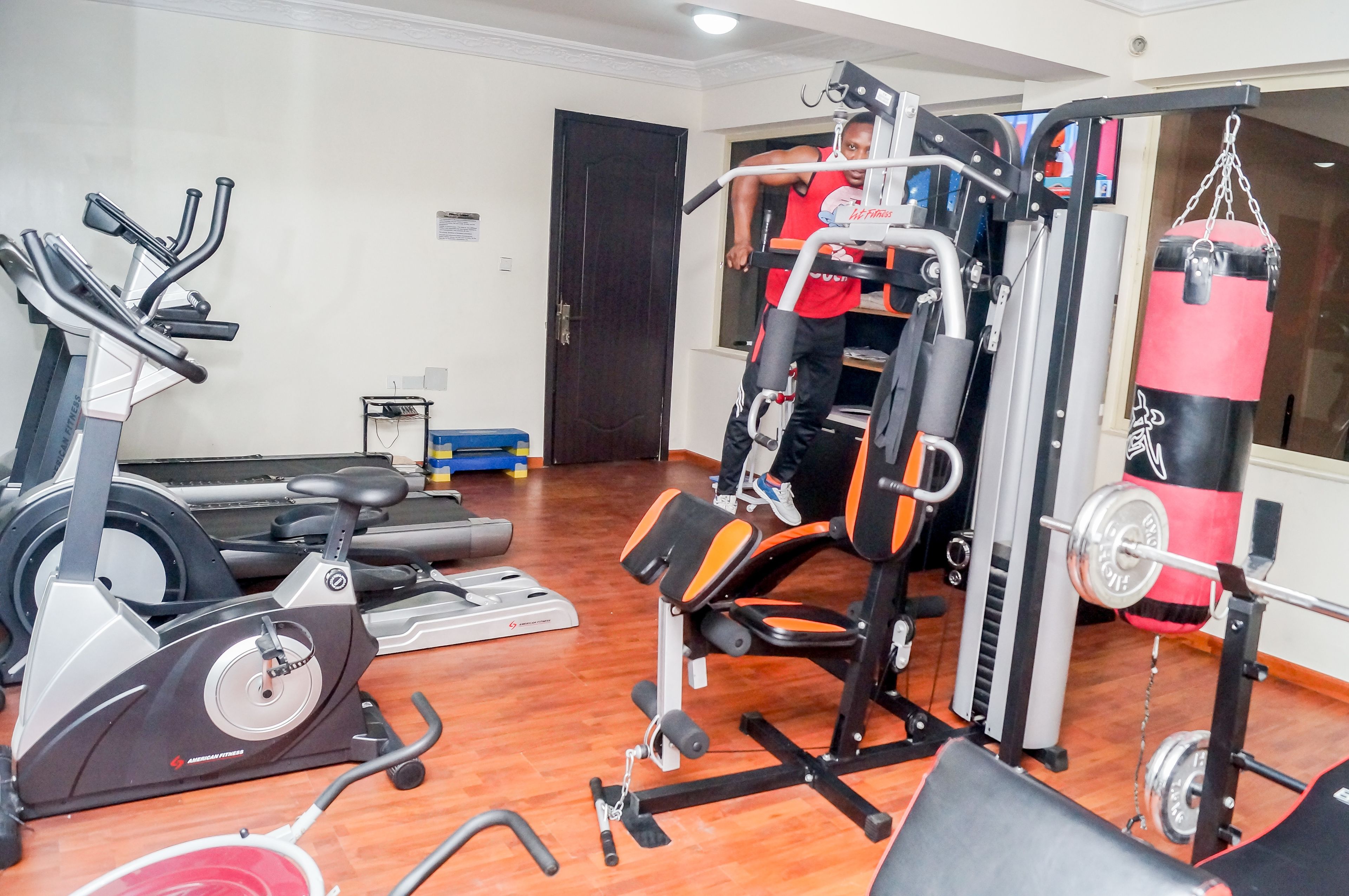 A gym with cardio machines, weightlifting equipment, and a punching bag.