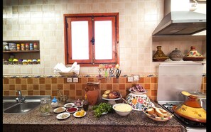 A kitchen with a granite countertop, a sink, a window, and various kitchen items.