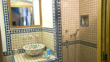 Ein Badezimmer mit Waschbecken, Spiegel und Dusche.
