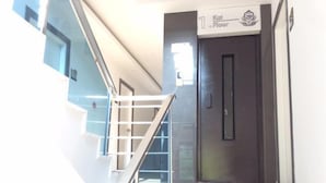 A staircase leading to the first floor with a glass railing and a door marked "1st Floor". - Copenhagen Hotel (Alanya)