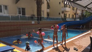 A swimming pool area with lounge chairs, a slide, and a poolside deck. - Copenhagen Hotel (Alanya)