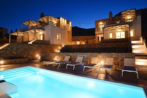 Alberca al aire libre, sombrillas en la alberca y camastros