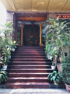 A set of outdoor stairs leading to a building entrance, flanked by potted plants. - New Lotus Hotel (Hanoi)