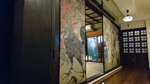 A traditional Japanese sliding door with floral patterns, a wooden floor, and a ceiling fan. - Yadoya Kyoto-Shimogamo (Kyoto)