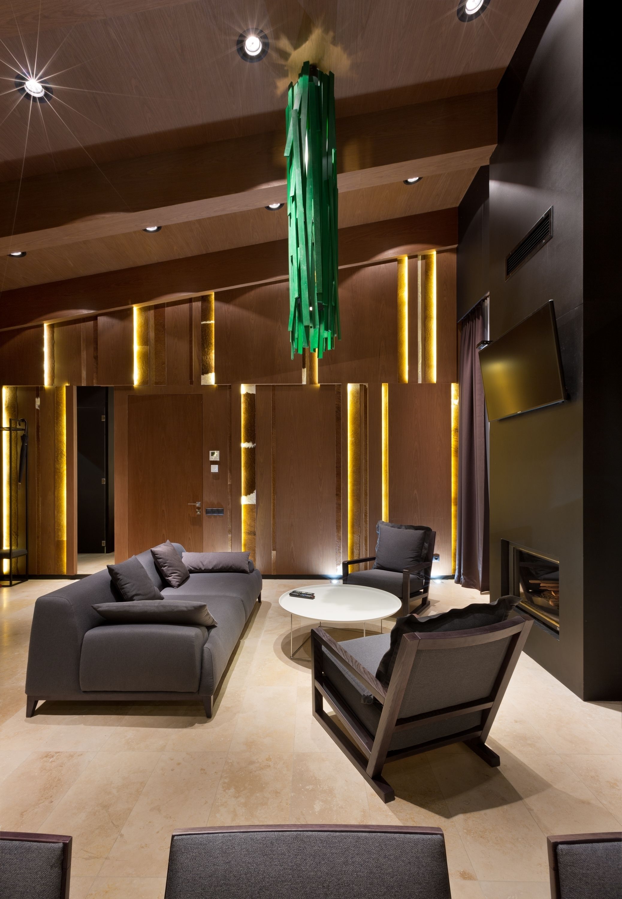 A modern interior with a sofa, armchair, and a round table.