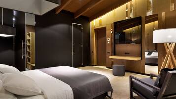 A modern bedroom with a bed, a chair, a vanity, and a mirror.