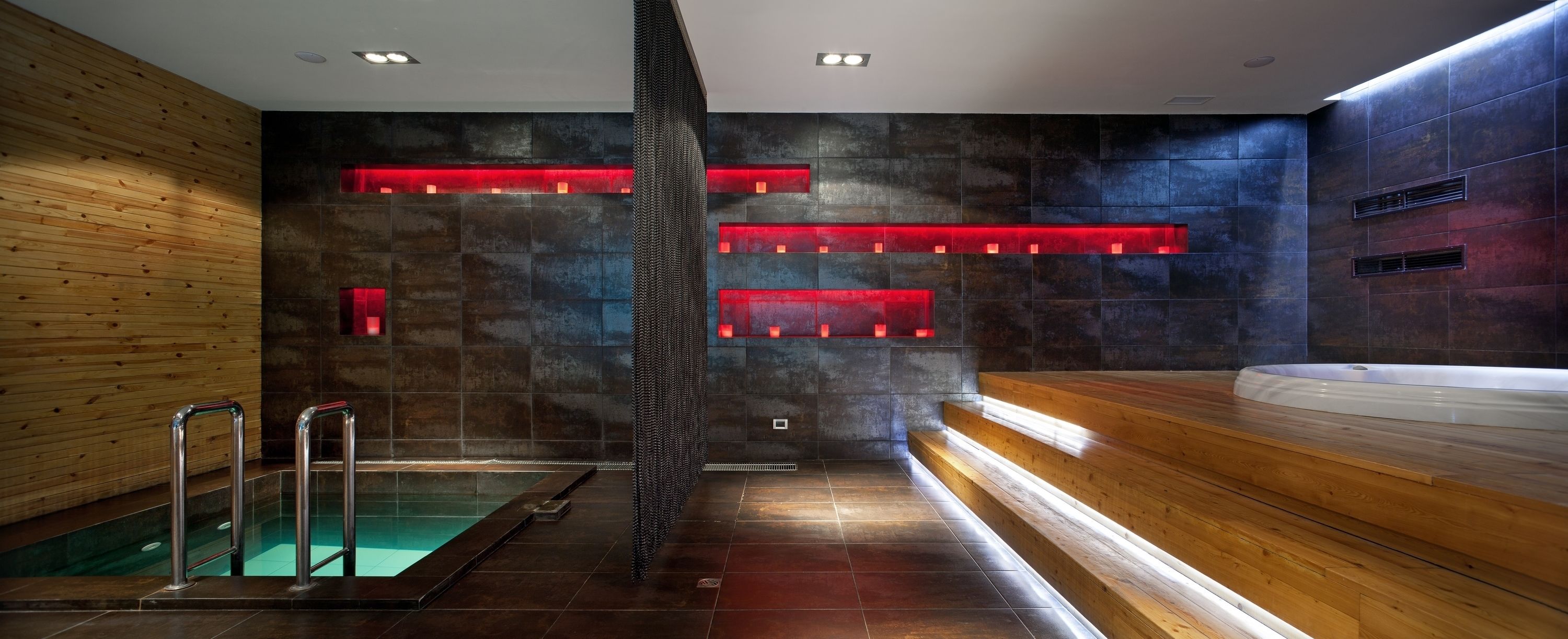 Een moderne spa met een houten bank, een whirlpool en een zwembad.