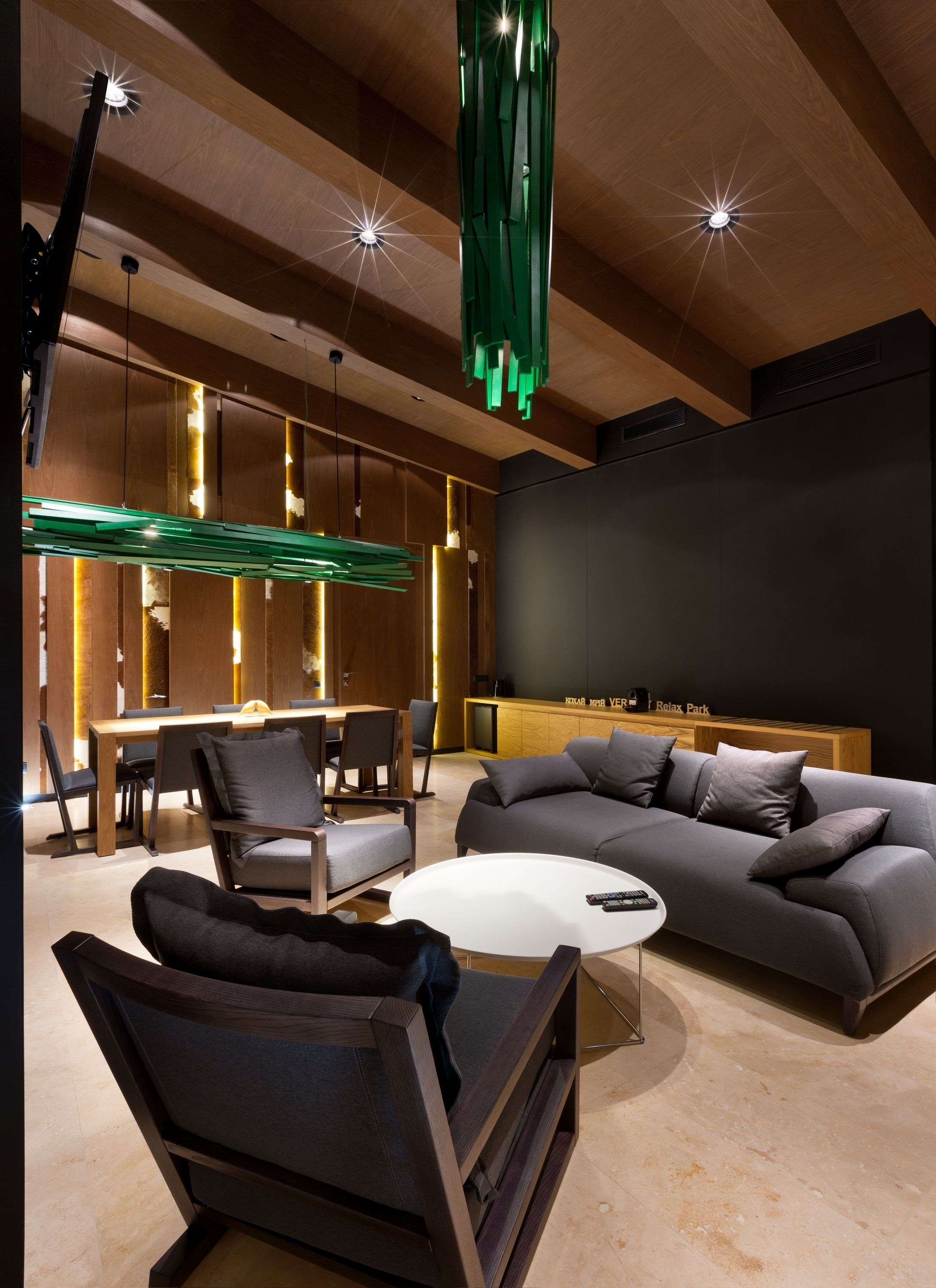 Una sala de estar moderna con un sofá seccional, una mesa redonda de centro y una zona de comedor con una mesa y sillas de madera.