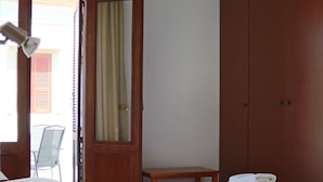 A hotel room with two beds, a wooden wardrobe, a desk, and a chair. - Stavros Pension (Rhodes)
