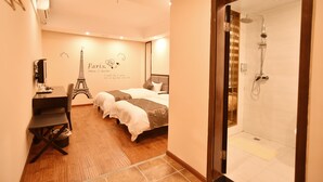 Habitación de hotel con cama, escritorio, silla, ducha y decoración con temática parisina en la pared.