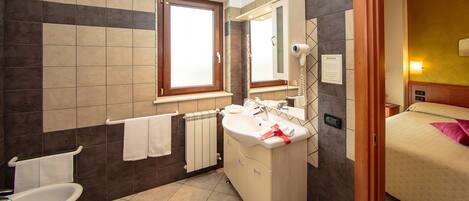 A modern bathroom with a sink, mirror, and towel rack.