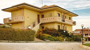 A two-story house with a balcony, a staircase, and a garden.