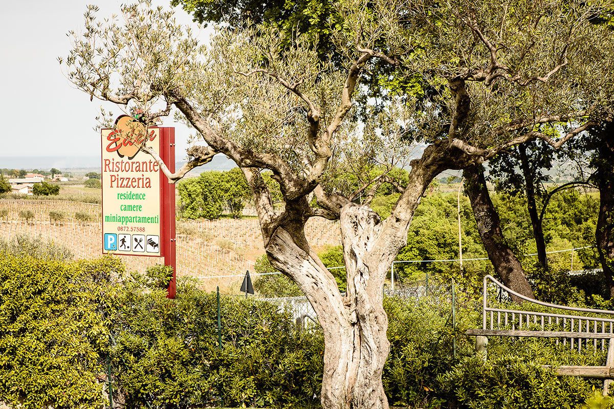 Une enseigne pour un restaurant-pizzeria proposant également des chambres et des mini-appartements à la location.