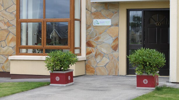 A building with a stone facade, a large window, and a door marked with the number 9. - Quay Rest  (Rooskey)