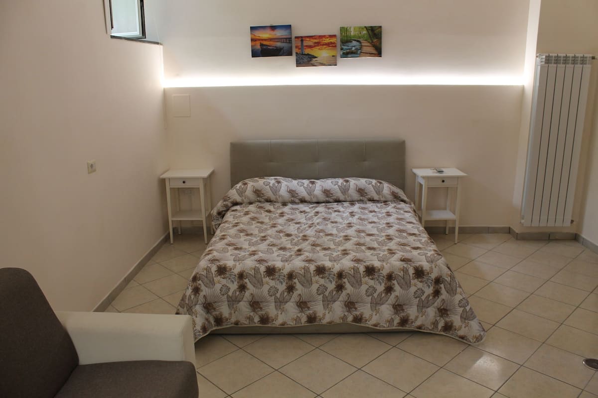 Une chambre à coucher avec un lit, des tables de chevet et des œuvres d’art murales.