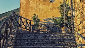 A stone staircase leading to a yellow building with a tiled roof and a lantern. - Casa Scola Agriturismo (Gragnano)