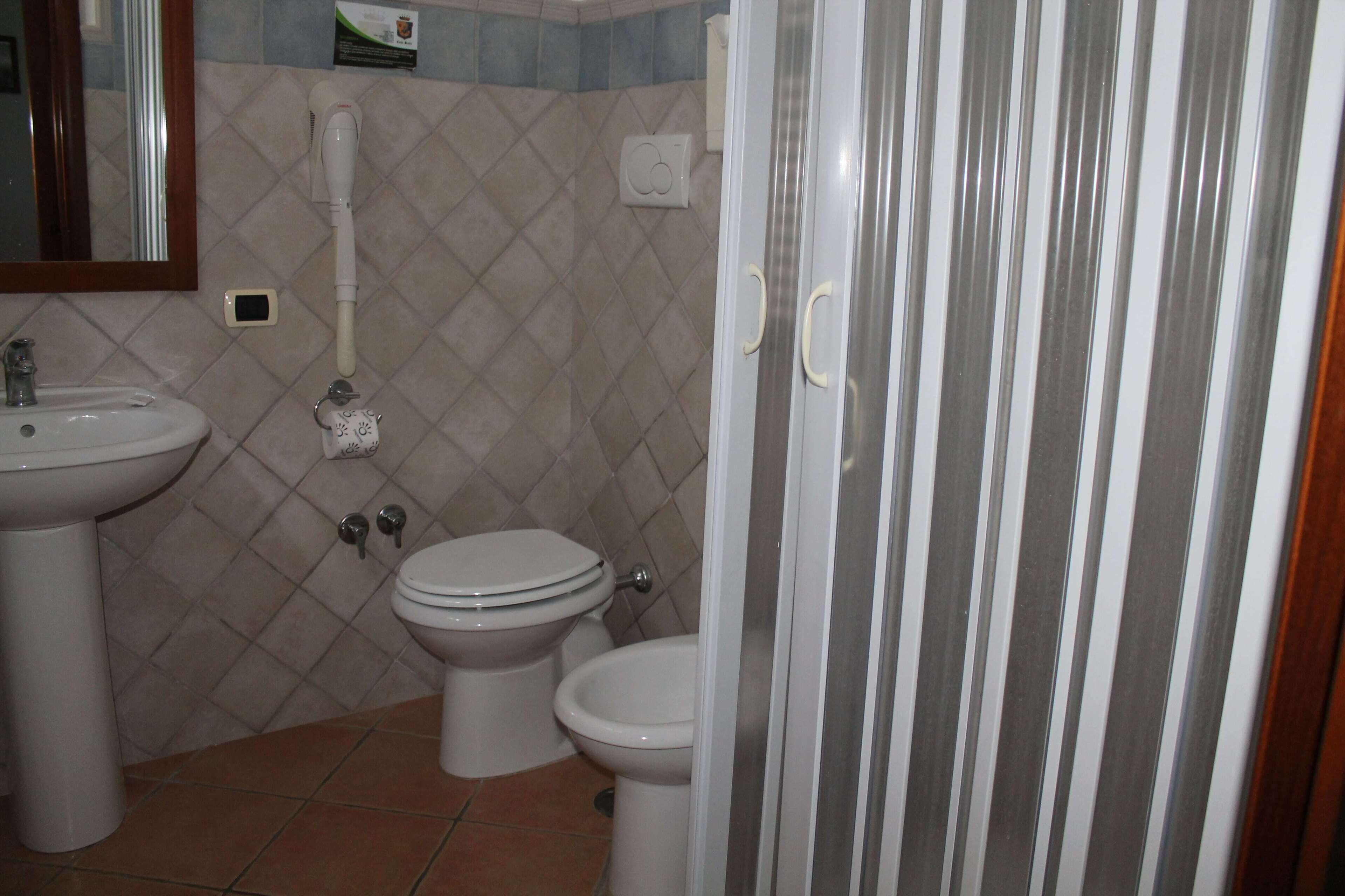 A bathroom with a sink, toilet, and shower.