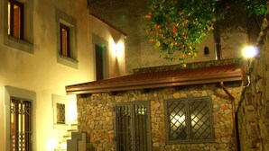 A building with stone walls and multiple windows, some with metal grilles. - Casa Scola Agriturismo (Gragnano)
