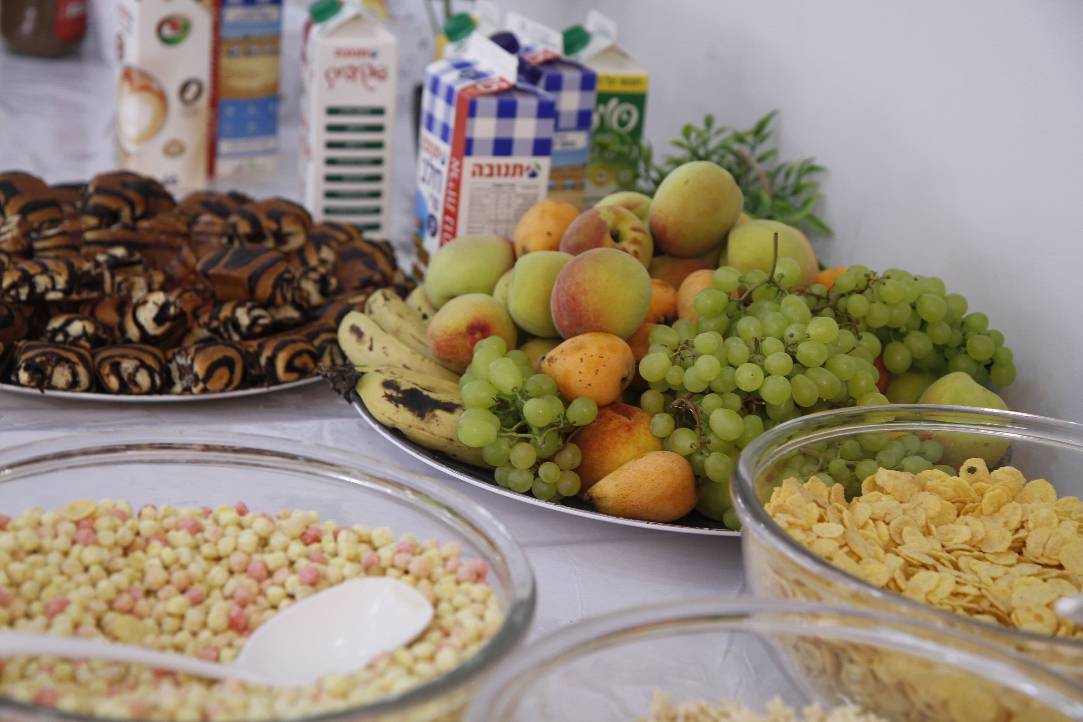A table with various food items including fruits, cereals, and snacks.