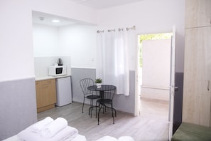 Habitación triple económica, 1 habitación, vistas al jardín | Cocina privada | Frigorífico, microondas, cafetera o tetera y hervidor eléctrico