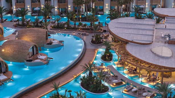 A multi-level pool area with various seating arrangements and a central water feature.