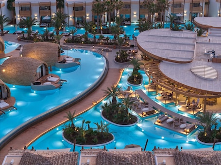 A multi-level pool area with various seating arrangements and a central water feature.