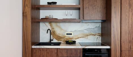 A kitchen with wooden cabinetry, a marble backsplash, a black sink, and a Bosch dishwasher.