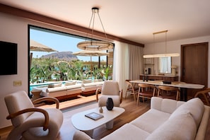 A modern hotel room with a large window, a pool view, a dining area, and a living room with a sofa and chairs.