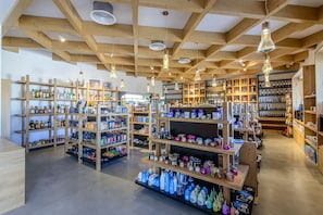 A store with wooden shelves stocked with various products, including bottles and containers.