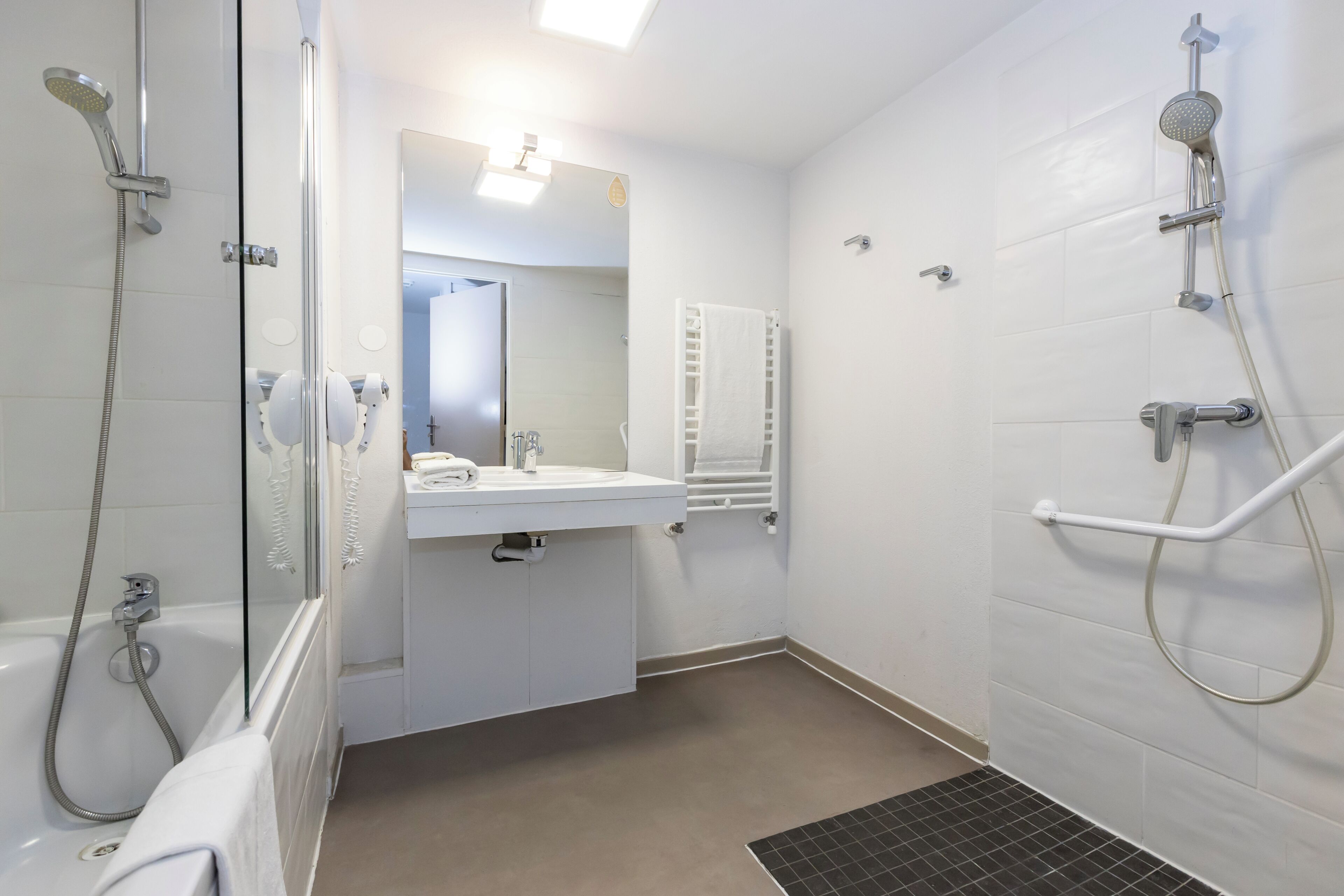 Une salle de bain avec une baignoire, une douche, un lavabo et un miroir.